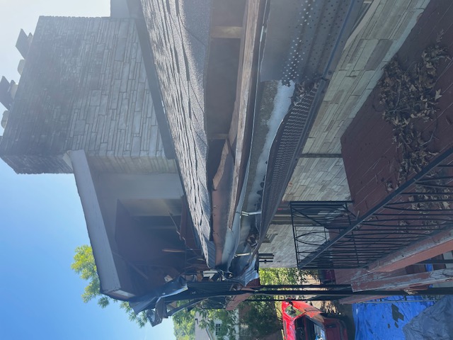 Before: damaged fascia, sagging gutter and open soffit at the roof edge