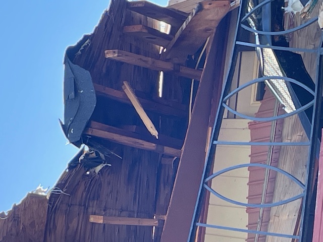 Before: torn-off eave exposing damaged rafters and roof decking