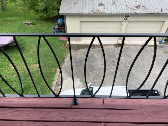 After: restored black iron balcony railing over a repainted deck