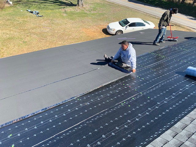 After: new low-slope roofing membrane rolled out and sealed by the crew